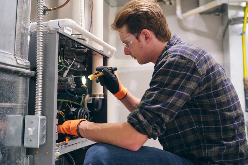 New high-efficiency furnace being installed in an Aurora home utility room
